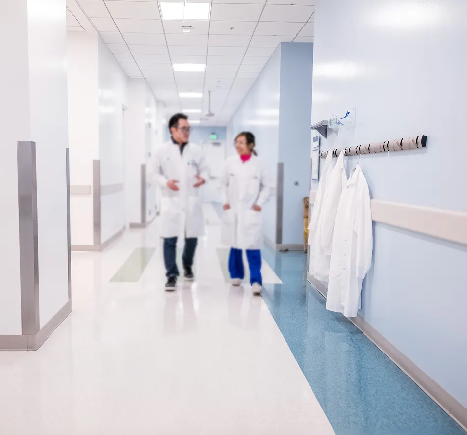 Two lab employees walking down a research facility hallway