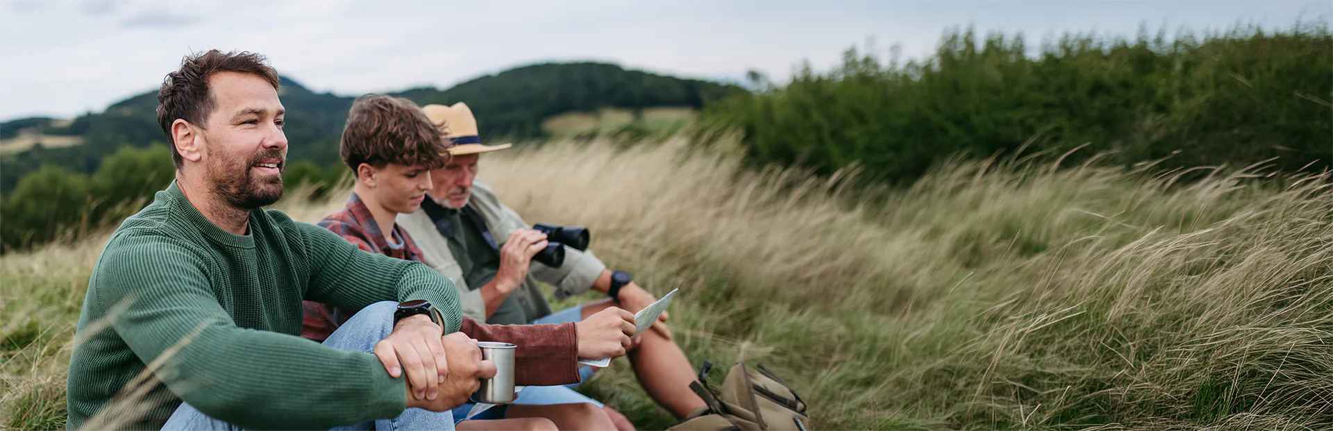 Three people relaxing together in a scenic mountain landscape